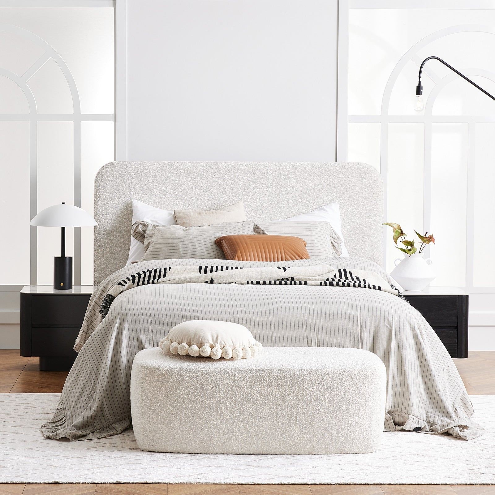 white rounded boucle bed frame with black bedside tables horgans
