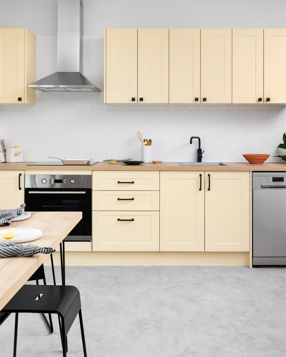 yellow kitchen cabinets with timber benchtop black handles and grey concrete floor